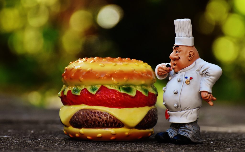 Soška kuchaře s hamburgerem.